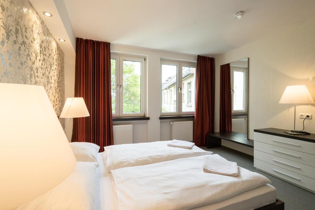 um quarto com 2 camas e 2 janelas em Waldhof Residenz em Offenbach