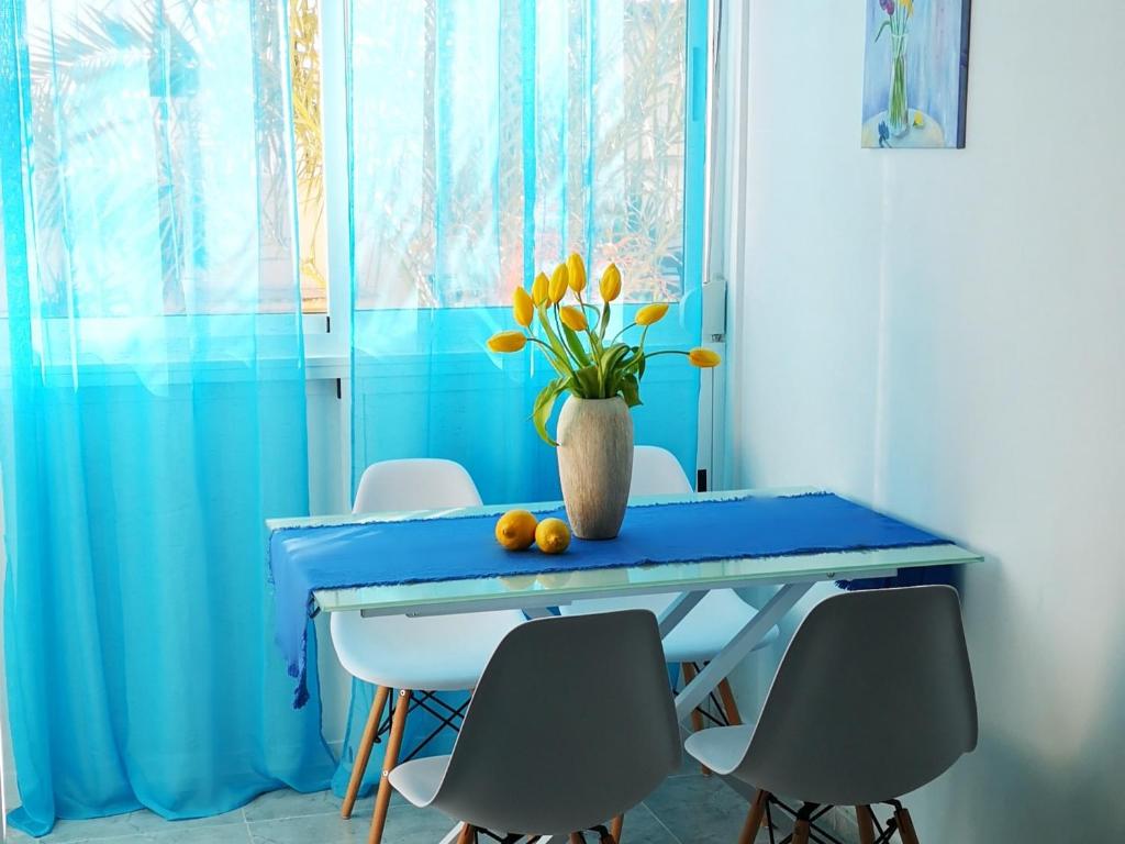 een blauwe eettafel met een vaas met bloemen erop bij Apartment Granada 302 Pool&Beach in Torrevieja