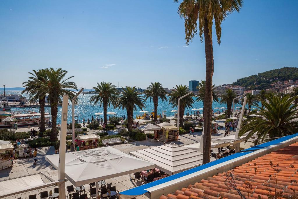 a view of a town with palm trees and the ocean at Guest House Imperial in Split