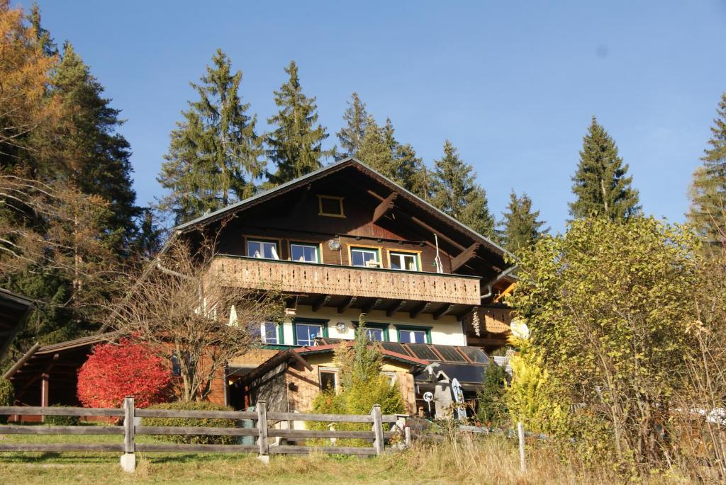 a large house in the woods with a fence at Sattelberg in Ramsau am Dachstein
