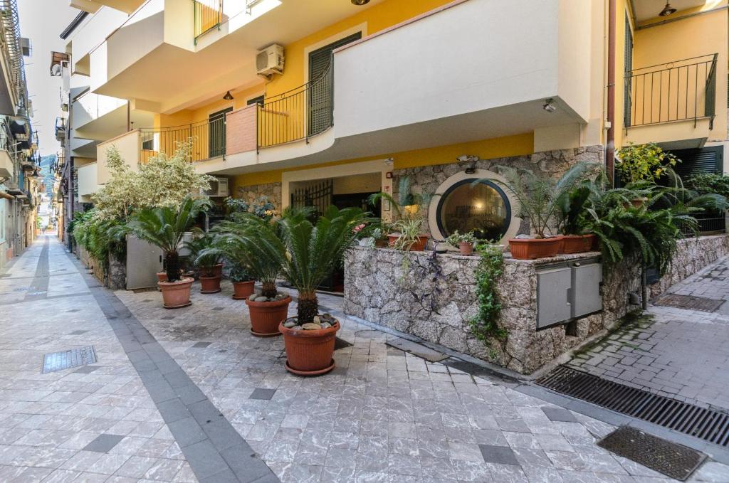 a street with potted plants in front of a building at Le Tartarughe Aparthotel in Letojanni