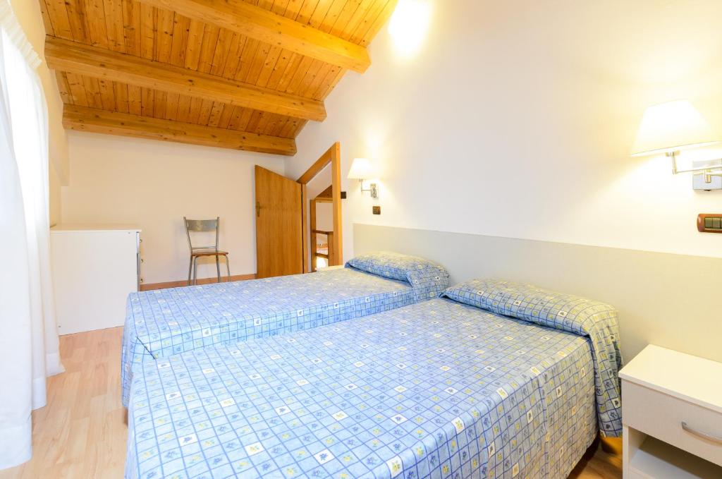 a bedroom with a blue bed with a wooden ceiling at Le Tartarughe Aparthotel in Letojanni
