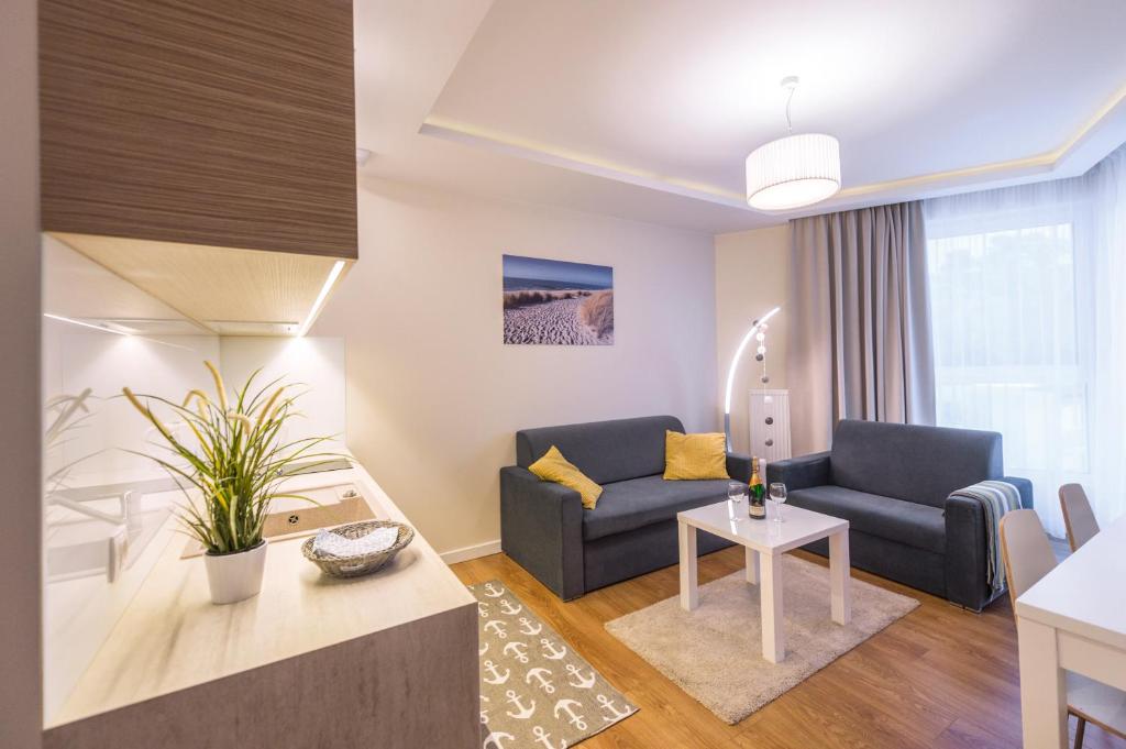 a living room with a couch and a table at Apartament DeLux Marina in Kąty Rybackie