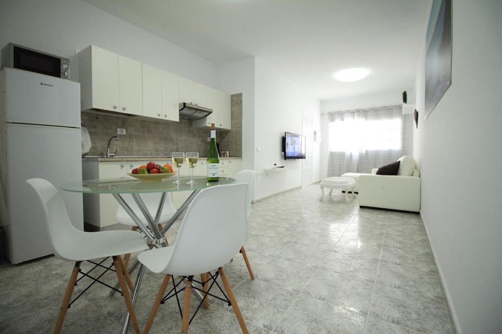 a kitchen and living room with a table and chairs at COTILLO SEA in Cotillo