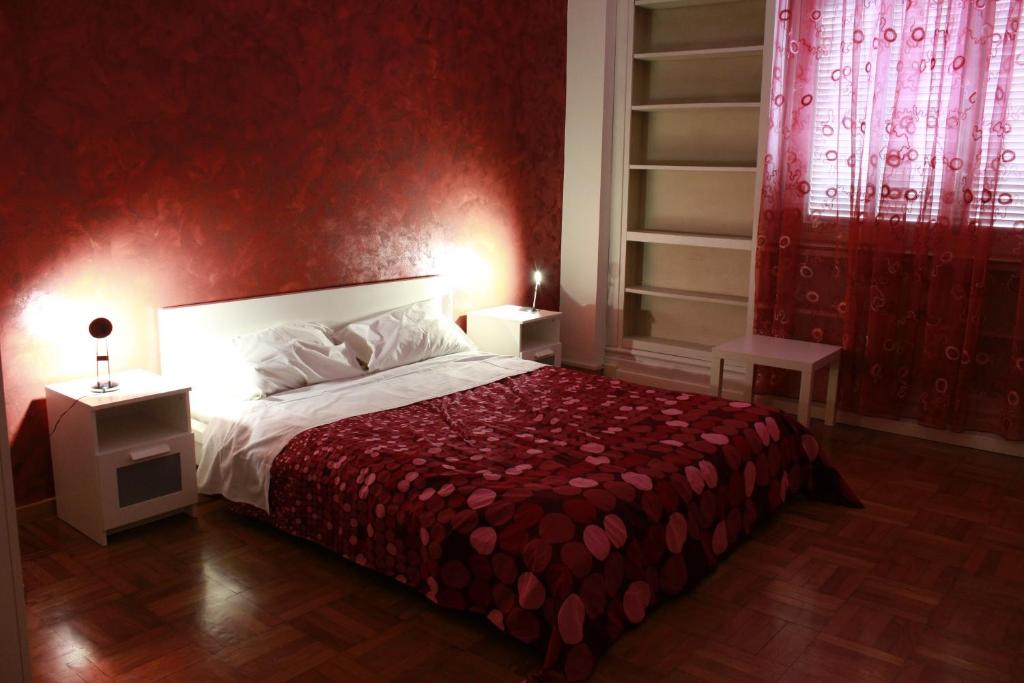 1 dormitorio con 1 cama con pared roja en Bologna Center Town, en Bolonia
