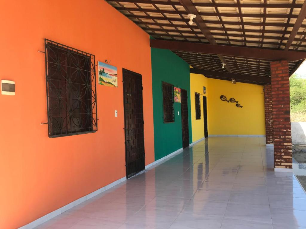 an empty hallway with orange and green walls at Chalés Porto do Céu in Aracati