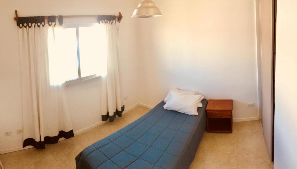 Un dormitorio con una cama azul y una ventana en BarrancasdelGolfo en 