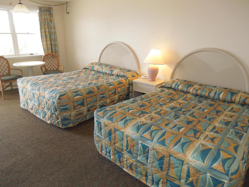 Habitación de hotel con 2 camas, mesa y sillas en The Jetty Motel, en Cape May