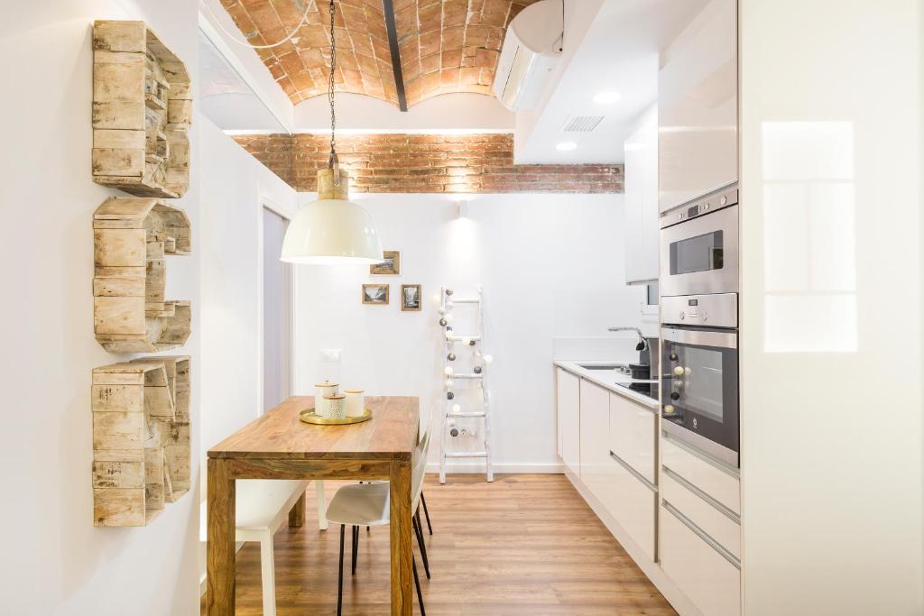 a kitchen with a wooden table and a dining room at Charming Parallel in Barcelona