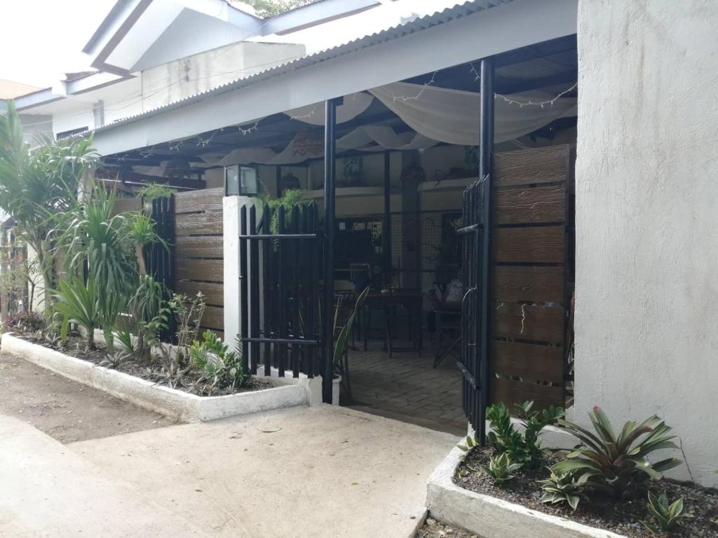 an entrance to a restaurant with a fence and plants at Cozy Inn Mactan in Mactan