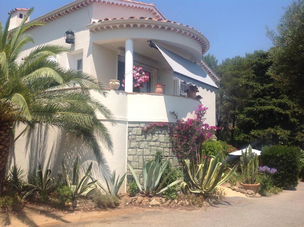 uma casa branca com plantas à frente em Rez de Villa Pébrier em Fréjus