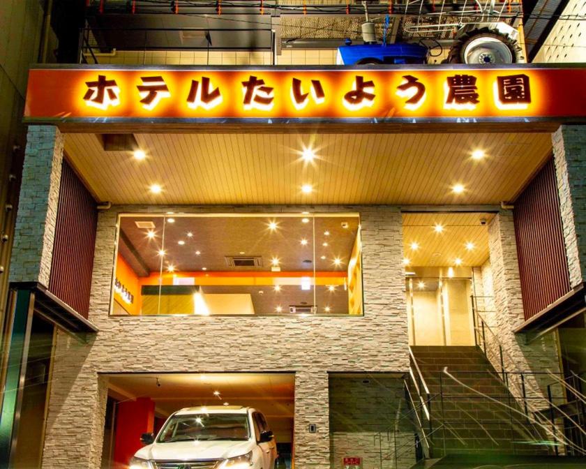 松山的住宿－Hotel Taiyo Noen Nibancho，前面有停车位的建筑