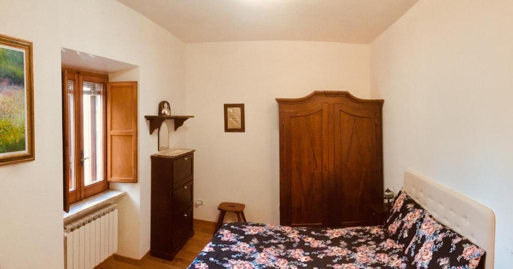 a bedroom with a bed and a wooden cabinet at Mini Appartamento Centro Storico in Pescocostanzo
