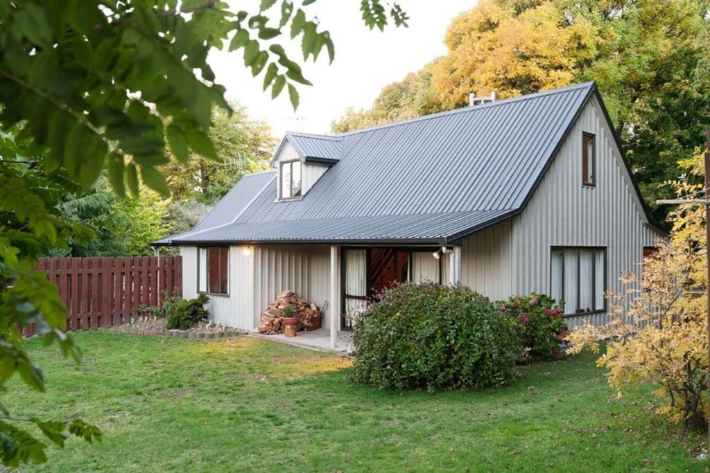a small white house with a black roof at Lazy Daze in Wanaka