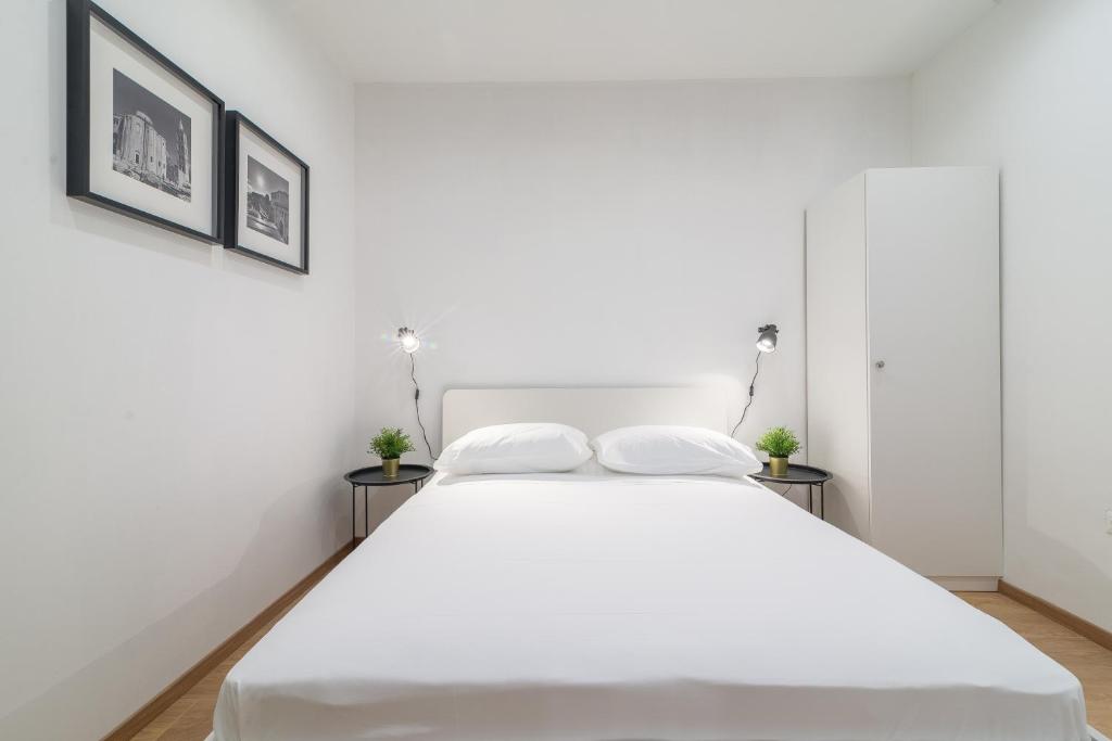 ein weißes Bett mit zwei Kissen auf einem Zimmer in der Unterkunft Studios & Apartments Porto in Zadar