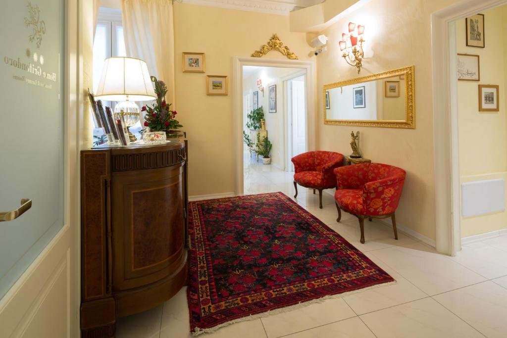 sala de estar con mesa y 2 sillas rojas en Home Grifondoro Affittacamere, en Génova