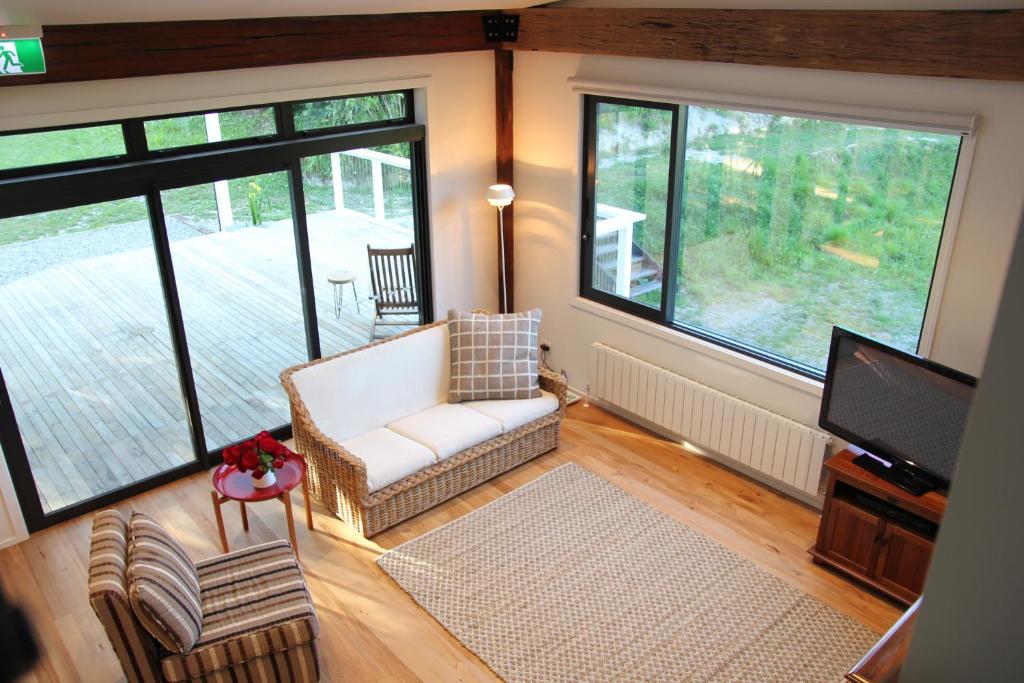 un soggiorno con divano e TV a schermo piatto di Korepo Lodge @ Ruby Bay a Nelson