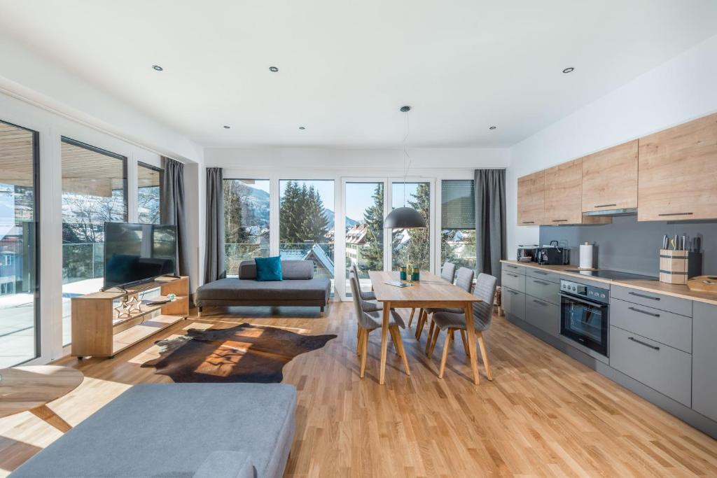 a kitchen and living room with a table and chairs at Deluxe Apartment Berglust in Schladming