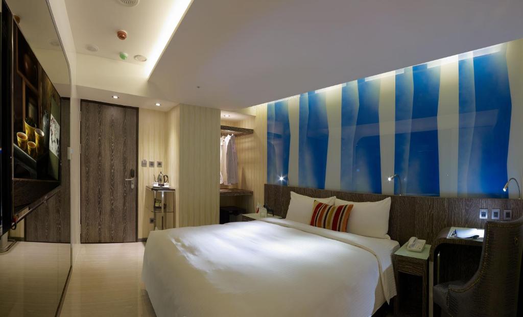 a bedroom with a large white bed and a colorful wall at Beauty Hotels - Hotel Bnight-Self Check-In Hotel in Taipei