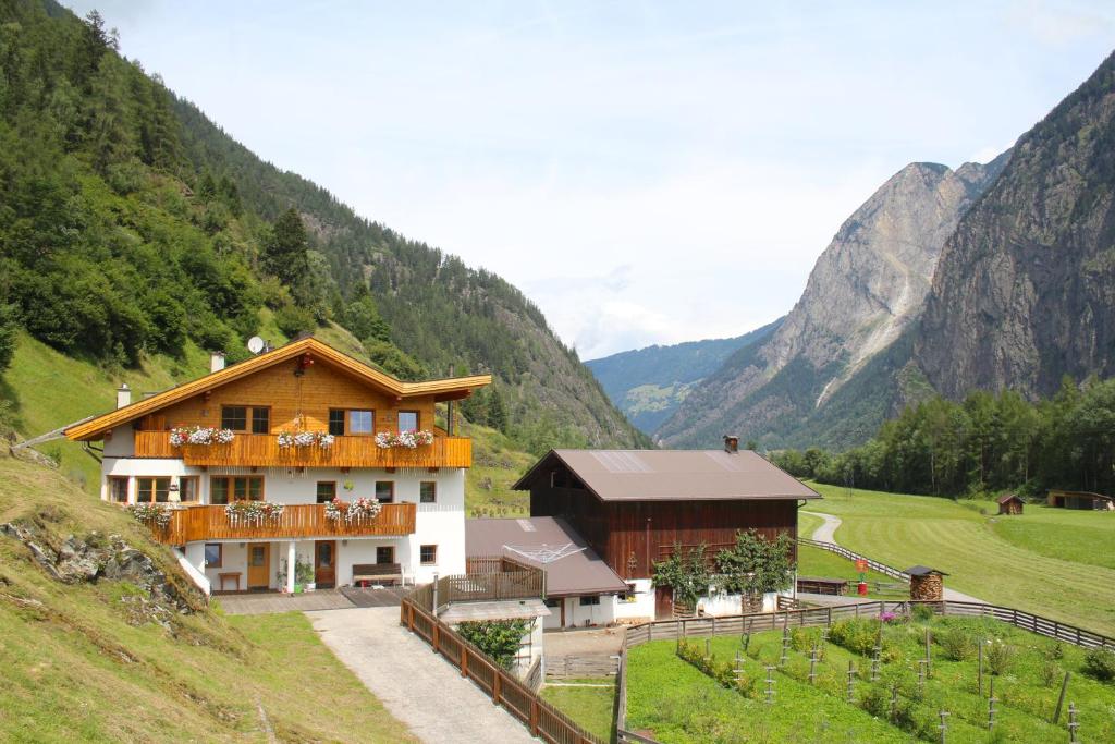 ein Gebäude auf einem Hügel mit Bergen im Hintergrund in der Unterkunft Michelas - Hof in Umhausen