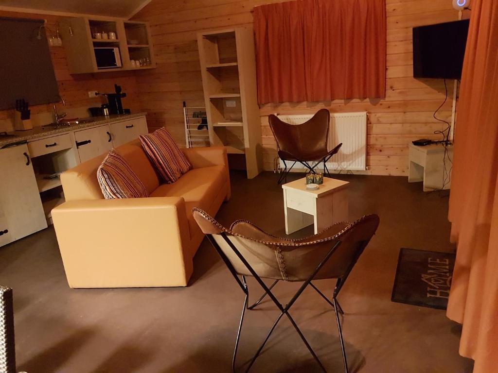 uma sala de estar com um sofá e duas cadeiras em Vakantiepark de Bronzen Eik em Sellingen