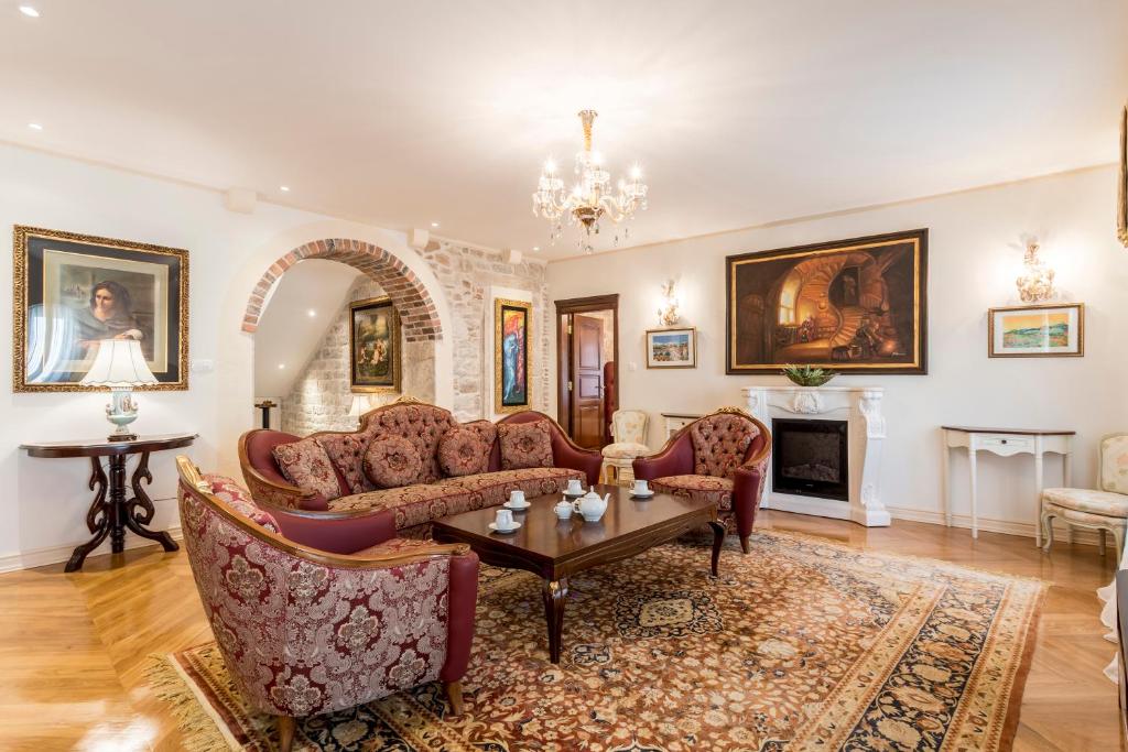a living room with couches and a table and a fireplace at Villa Nepos Hotel in Split