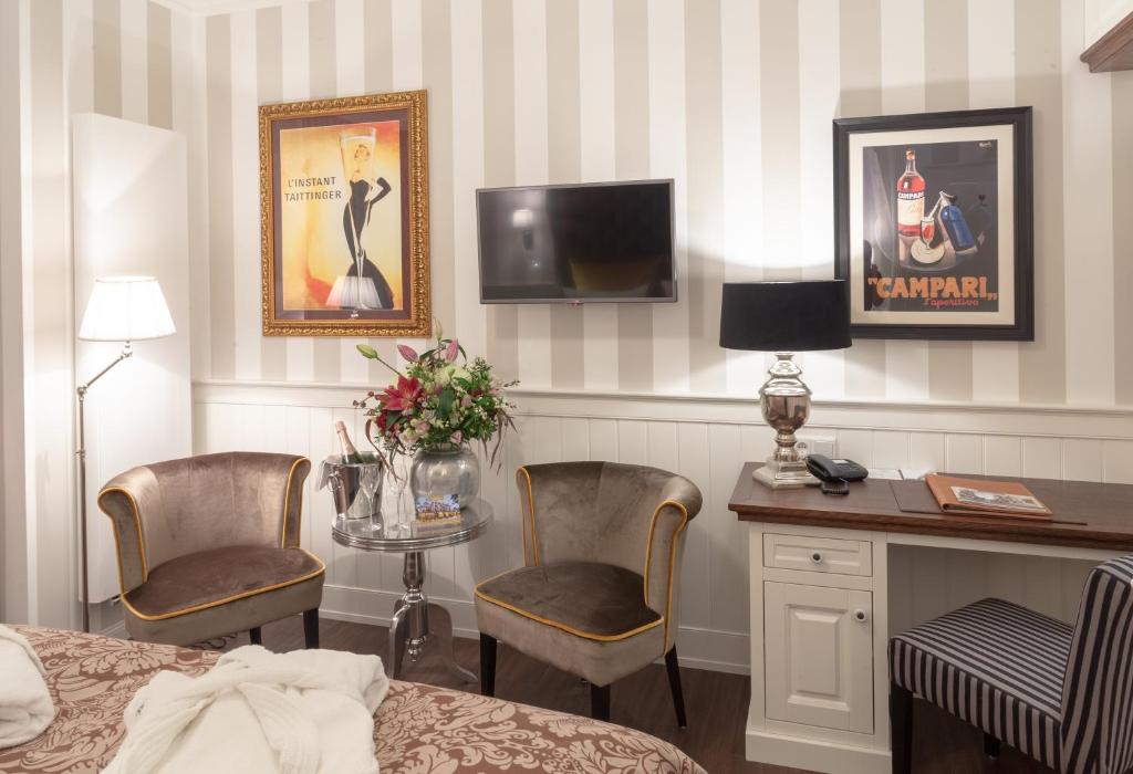 a hotel room with a bed and a desk and a tv at Europa Hotel Kühlungsborn in Kühlungsborn