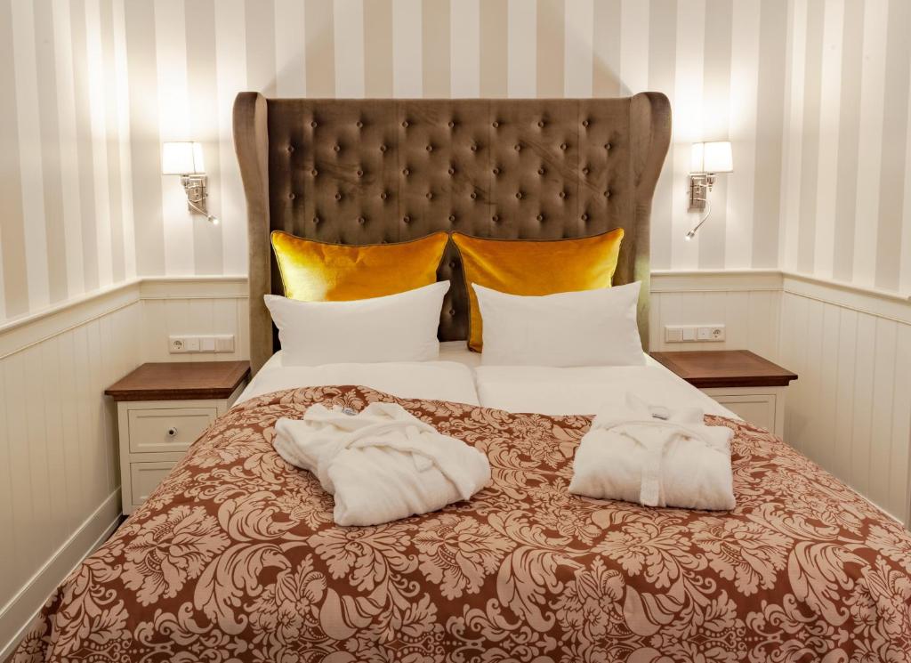 a bedroom with a large bed with two towels on it at Europa Hotel Kühlungsborn in Kühlungsborn