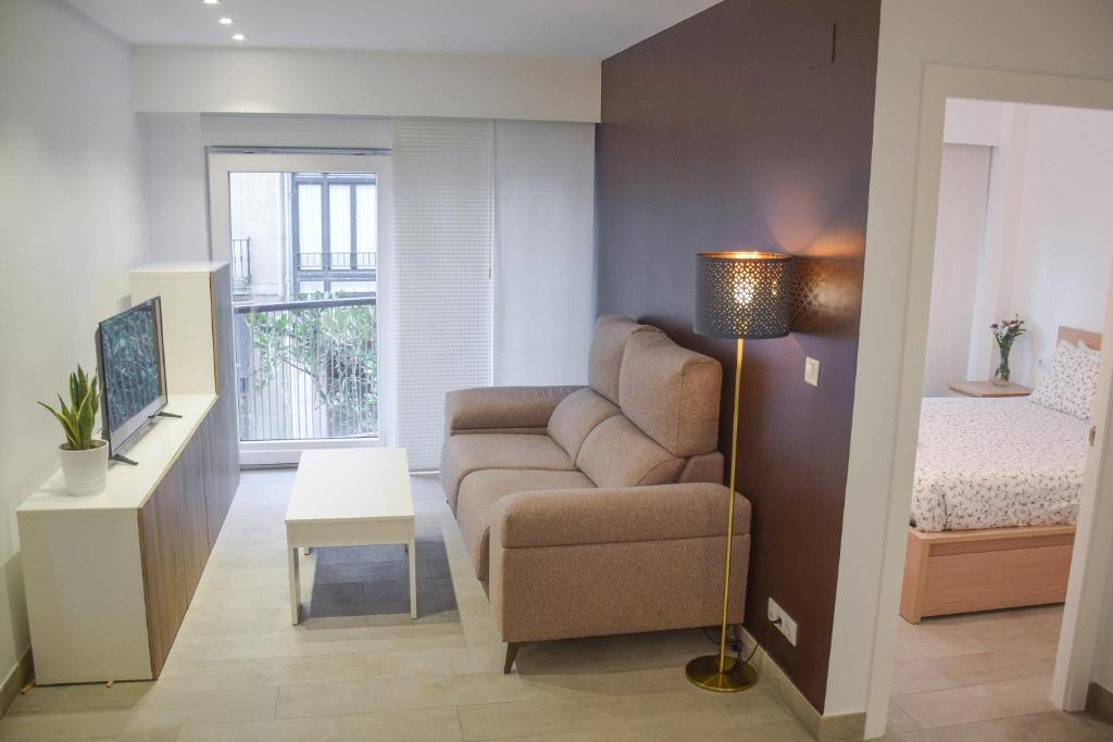 een woonkamer met een bank en een bed bij Modern & spacious apartment near La Concha Bay in San Sebastian