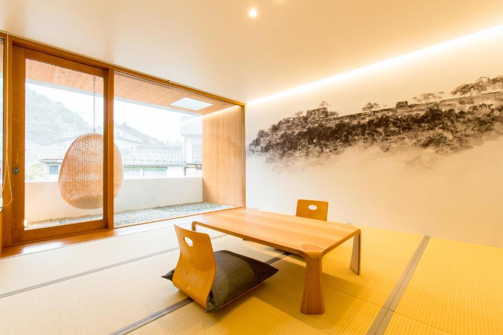 a room with a wooden table and a window at UTSUROI Tsuchiya Annex in Toyooka