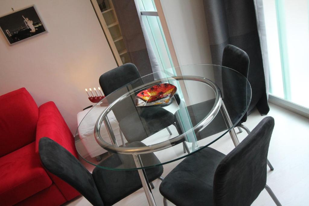 una mesa de cristal con sillas negras y una pizza. en baricarulli52 en Bari