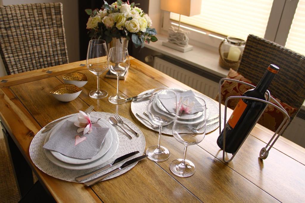 a wooden table with plates and wine glasses on it at Brockenblick in Goslar