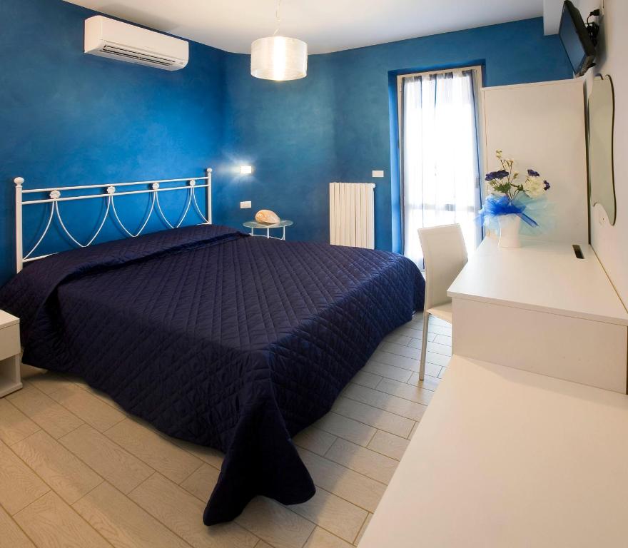 sypialnia z łóżkiem z niebieską ścianą w obiekcie La Perla Del Conero Affittacamere w mieście Numana