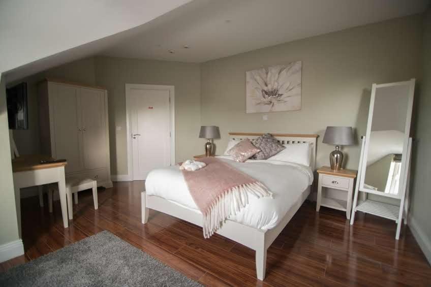 a bedroom with a bed and two tables and a mirror at West Haven House in Doolin