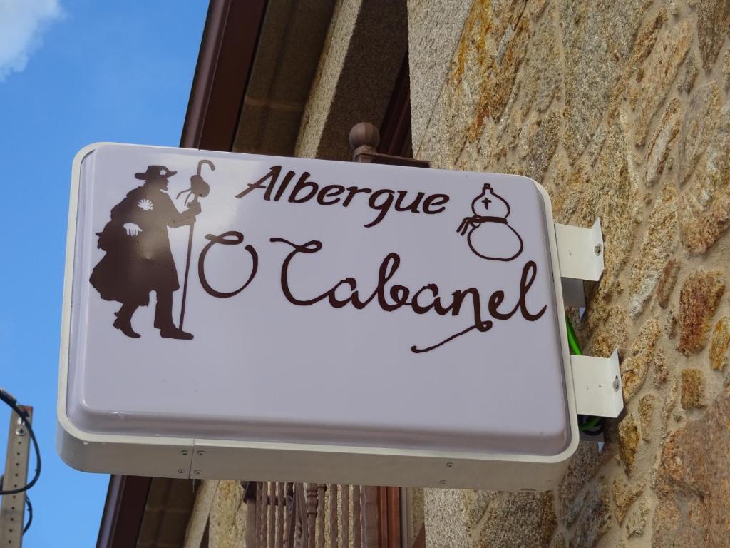 ein Schild an der Seite eines Gebäudes in der Unterkunft O Cabanel Albergue-Bar in Villastose