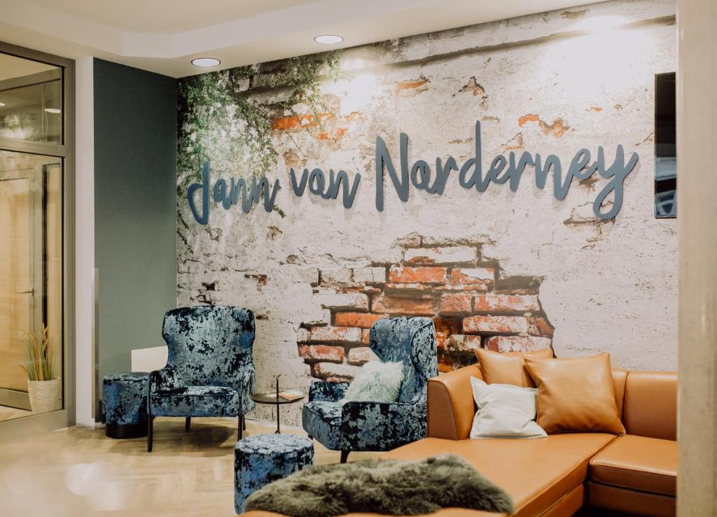 Hotel Jann von Norderney في نورديرني: غرفة معيشة مع أريكة وجدار من الطوب