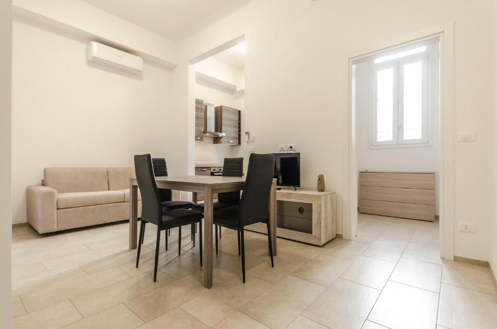 a living room with a table and chairs and a couch at S.Felice Apartments in Bologna