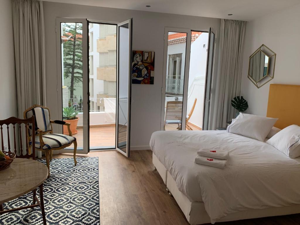 a bedroom with a white bed and a table and chair at Central - São Pedro Boutique in Funchal
