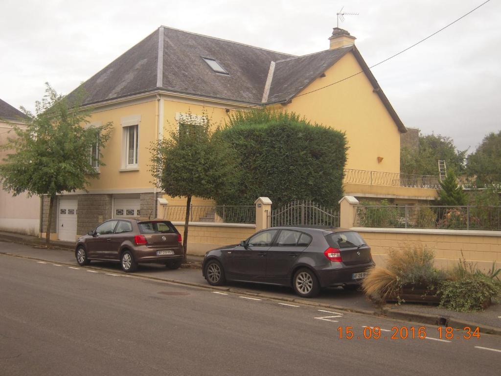 two cars parked in front of a yellow house at 54 AV ROGERS MARTIN DU GARD in Bellême