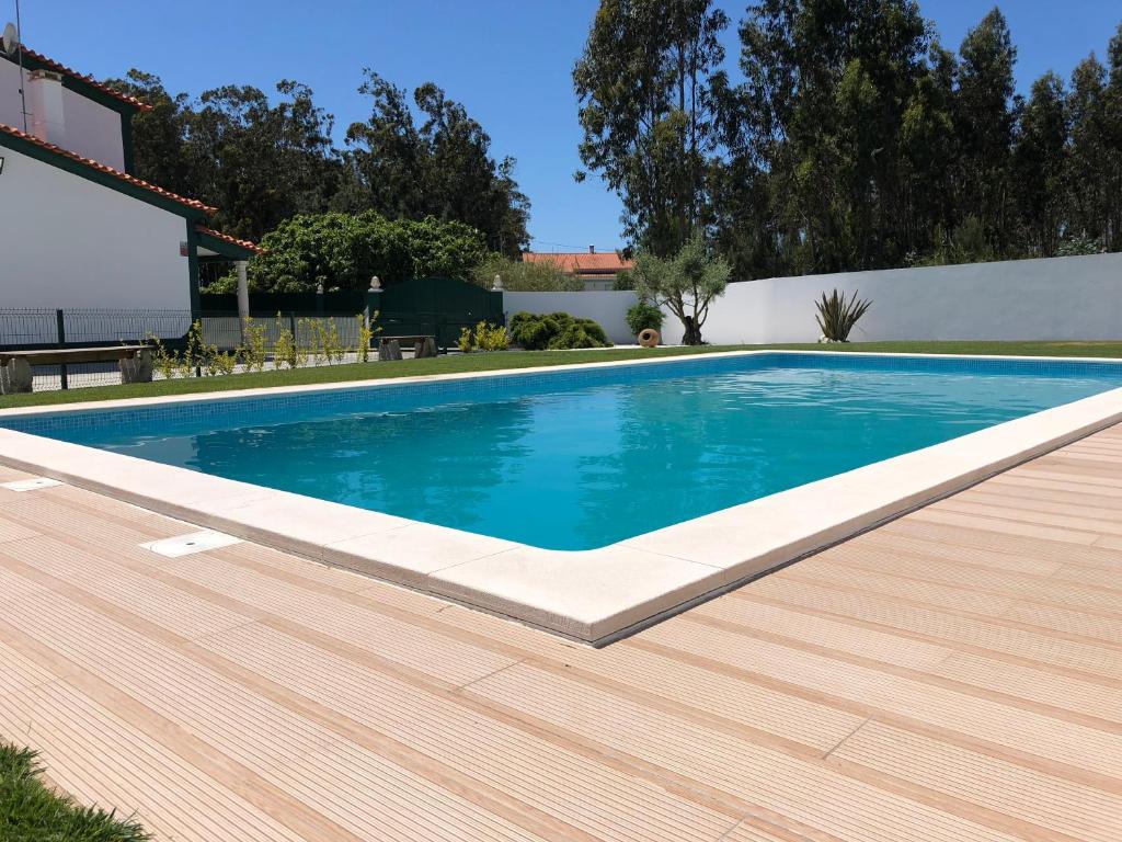 una piscina con terraza de madera junto a una casa en Paradise Valley House en São Martinho do Porto