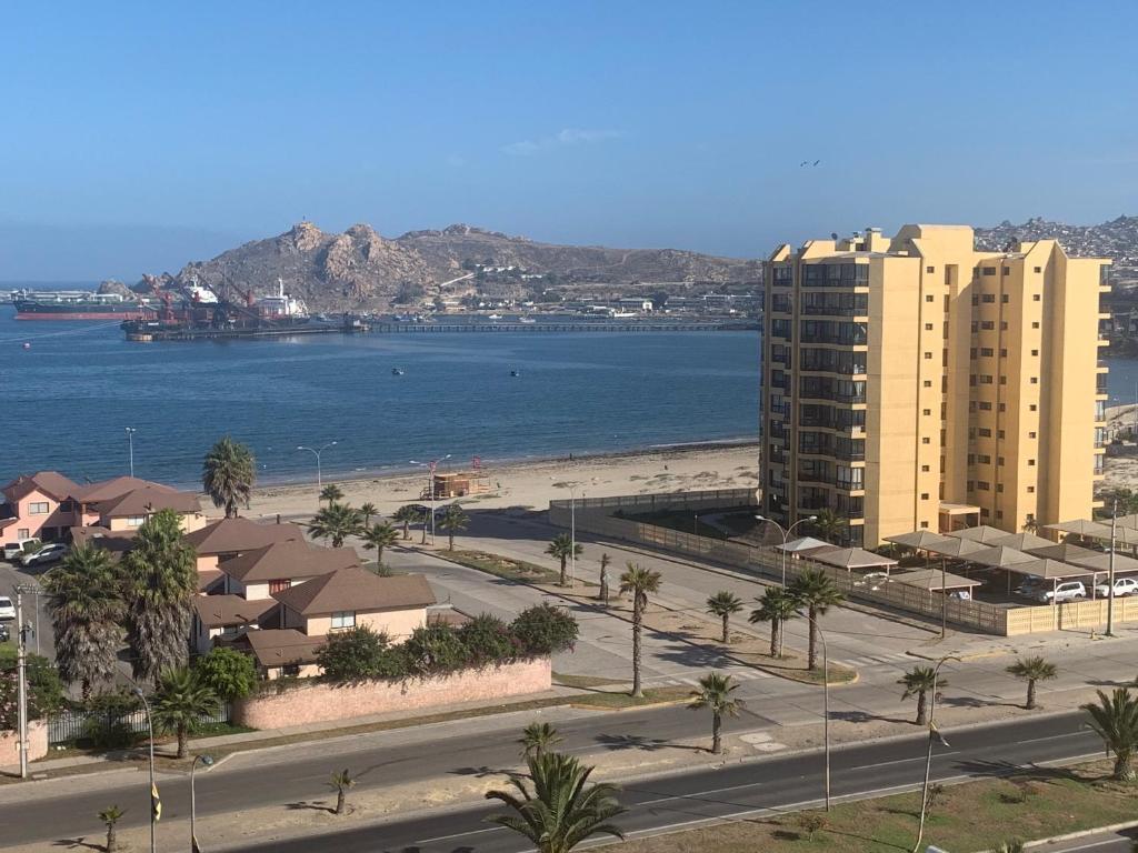 a view of a beach and buildings and the ocean at Pronejoet Departamentos La Herradura in Coquimbo
