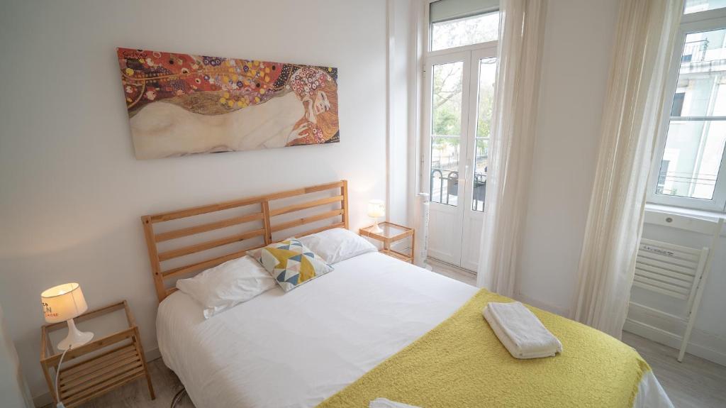 リスボンにあるSão Lázaro Lisbon Apartmentsのベッドルーム(白いベッド、黄色い毛布付)