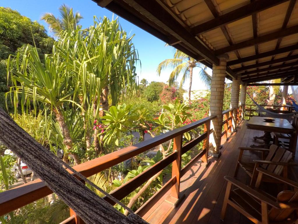 a hammock on a porch with a view of the ocean at Pousada Zia Teresa in Pipa