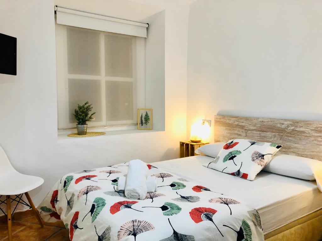 a bedroom with a bed with a comforter on it at Pensión La Cantarera in Cádiz