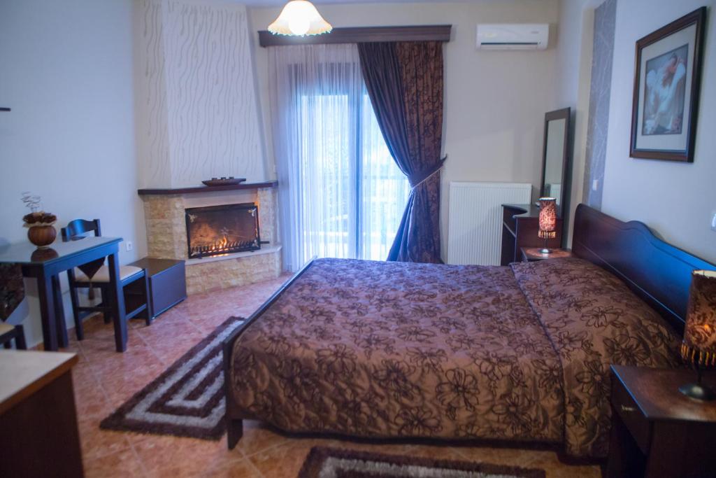 ein Hotelzimmer mit Bett und Kamin in der Unterkunft Ydraktis in Orma