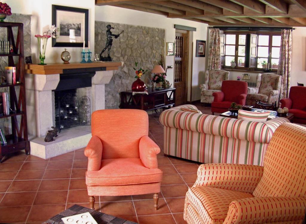 a living room with two chairs and a fireplace at Hotel Aldama Golf in Quintana de Llanes