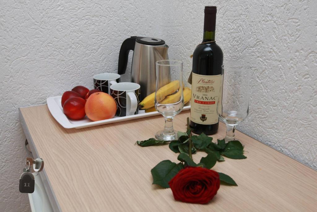 a bottle of wine and some fruit on a table at Villa Andjelina in Budva