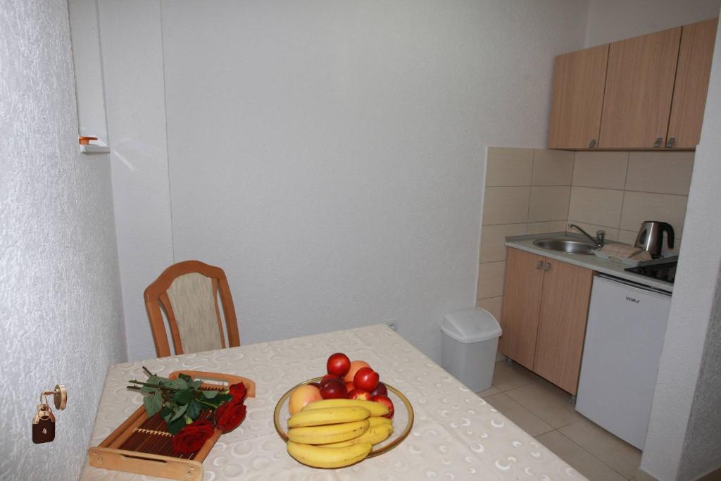 a kitchen with a table with a plate of fruit on it at Villa Andjelina in Budva