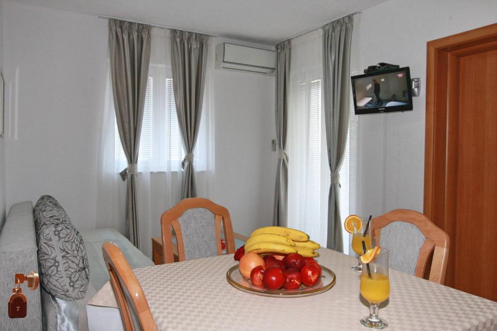 a dining room table with a plate of fruit on it at Villa Andjelina in Budva