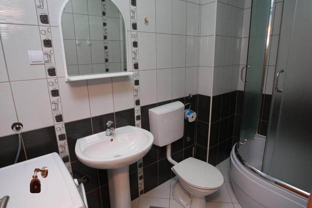 a bathroom with a sink and a toilet and a mirror at Villa Andjelina in Budva